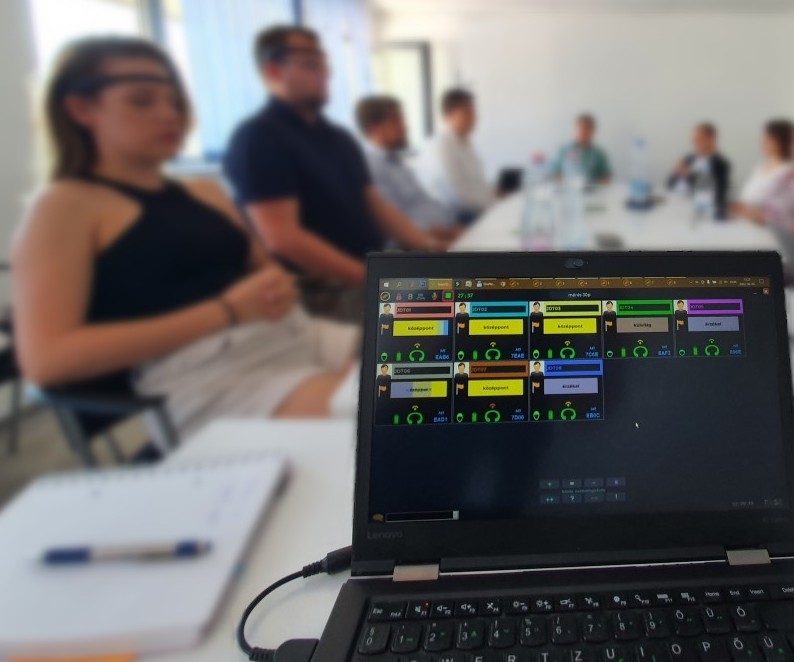 A TeamFlow group session with athletes wearing EEG headbands and a laptop showing real-time session monitoring